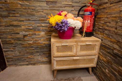 a fire extinguisher and flowers on top of a dresser at Airstaybnb in Manchester