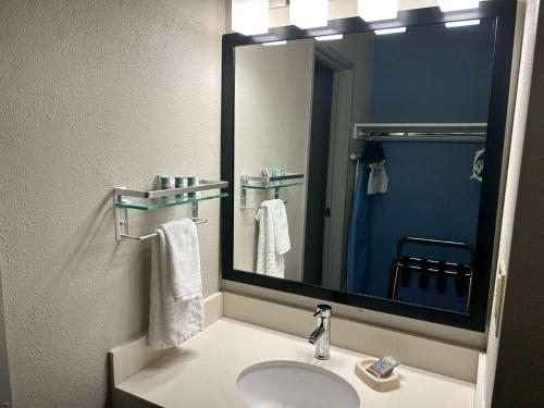a bathroom with a sink and a large mirror at Best Western Ottumwa Inn & Suites in Ottumwa
