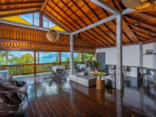 Una gran sala de estar con un sofá y sillas. en Eco Baepi Residence, en Ilhabela