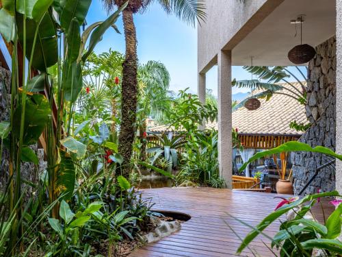 a patio with a bunch of trees and plants at Eco Baepi Residence in Ilhabela