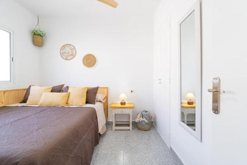 a small bedroom with a bed and a door at Privilegiado-Tarragona-50mPlaya-WIFI-Pool-Relax8 in Tarragona
