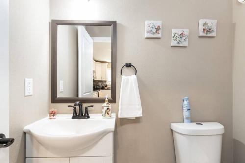 La salle de bains est pourvue d'un lavabo, d'un miroir et de toilettes. dans l'établissement Birch Hill Retreat Great location2+gArAge+AurorA, à Fairbanks