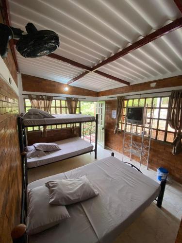 a room with two bunk beds and a tv at Hotel Piscina Macaliz in Subía