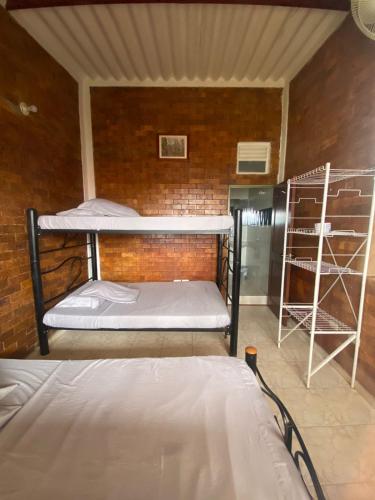 two bunk beds in a room with a brick wall at Hotel Piscina Macaliz in Subía