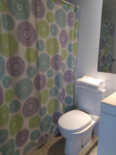 a bathroom with a toilet and a shower curtain at Depto. Nautilus Piso 11 in Iquique