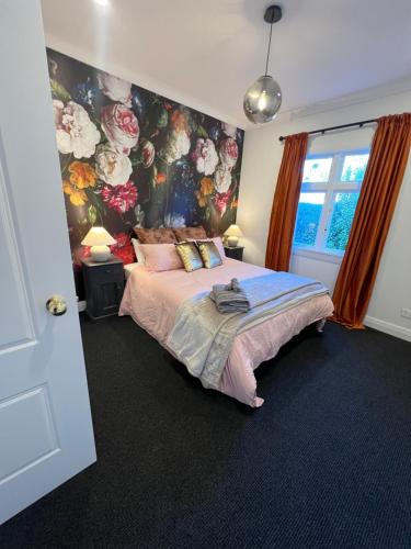 a bedroom with a bed with a floral wall at Pinot Villas in Martinborough 