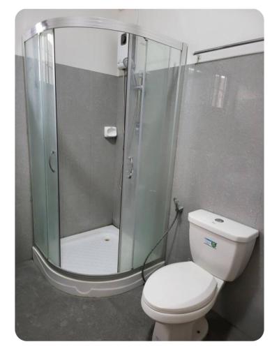 a bathroom with a toilet and a glass shower at Kame House in Bacoor