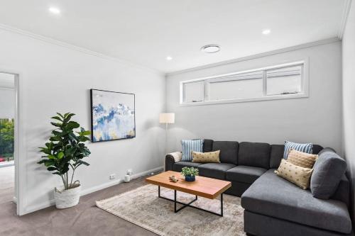 a living room with a couch and a table at Marina Escape - Contemporary Coastal Living in Shellharbour