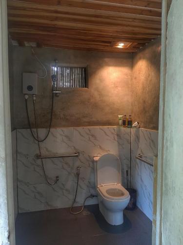 a bathroom with a toilet and a shower at Cabanas de Nacpan Camping Resort in El Nido