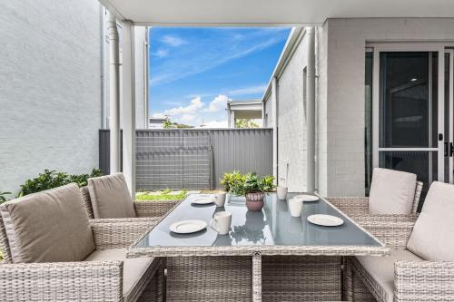 a patio with a table and two chairs at Marina Escape - Contemporary Coastal Living in Shellharbour