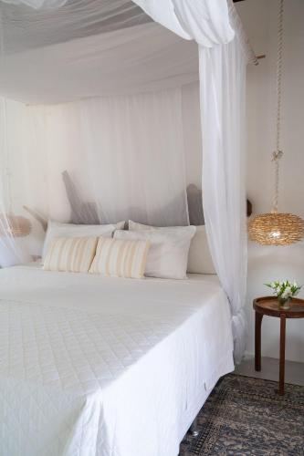 a bedroom with a white bed with a canopy at Orixás Residence in Morro de São Paulo