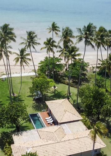 an aerial view of a resort with palm trees and the beach at Orixás Residence in Morro de São Paulo