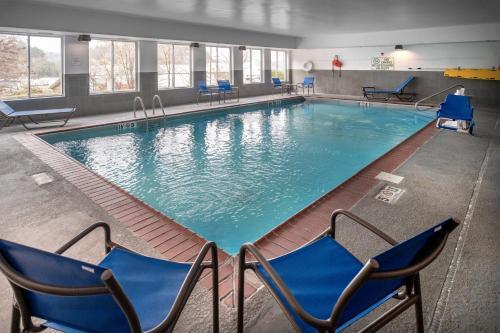 a large swimming pool with blue chairs and chairs at Holiday Inn Express and Suites Hazard, an IHG Hotel in Hazard