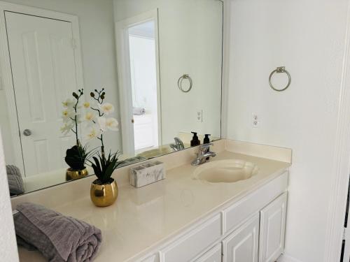 a white bathroom with a sink and a mirror at Feel Home at Frisco in Frisco