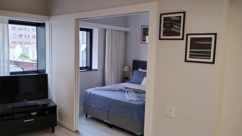 a bedroom with a bed and a mirror at Flat Charmoso Jardim Paulista in Sao Paulo
