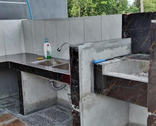 a kitchen with a sink in a concrete wall at PD ROOM STAY in Port Dickson