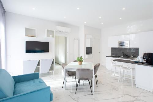 a white kitchen and dining room with a table and chairs at Tema Suites in Naples
