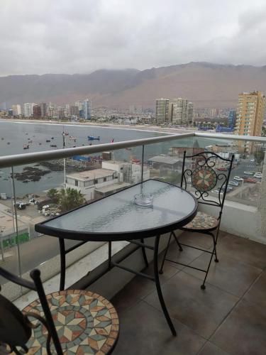 a table and chairs on a balcony with a view at Depto. Nautilus Piso 11 in Iquique