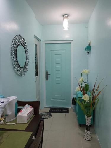 a hallway with a blue door and a vase of flowers at Mistow Saekyung Condo in Lapu Lapu City