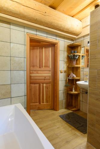 baño con bañera y puerta de madera en SRUB KVETONOV, en Kaplice