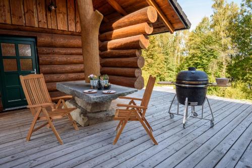 a patio with a grill and chairs on a cabin at SRUB KVETONOV in Kaplice