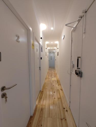 a long hallway with a wooden floor and white walls at Apartamento Sebastian in Lisbon