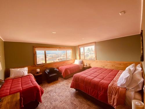 a hotel room with two beds and a window at Esquina Huella Patagónica in Coihaique