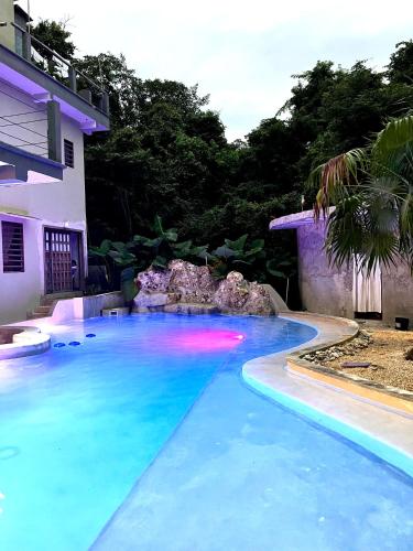 a swimming pool in front of a house at Hokhmah Heart Hotel in Puerto Morelos