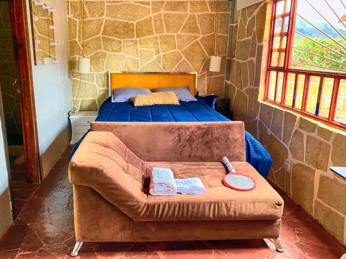a bedroom with a bed and a couch with towels on it at CASA DE PIEDRA EL ZAPATO in Suesca