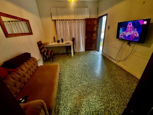 ein Wohnzimmer mit einem Sofa und einem TV an der Wand in der Unterkunft Casona in Laferrere