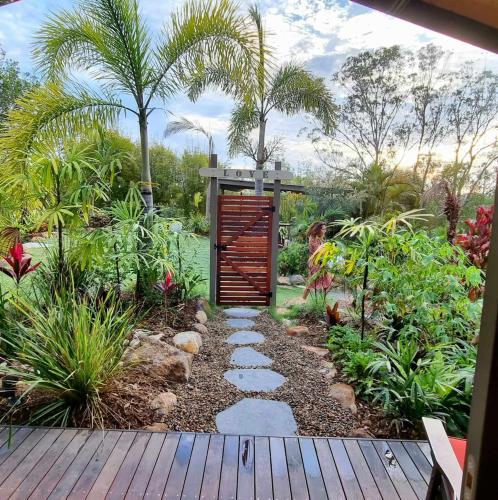a garden with a pathway and a wooden gate at Healing Garden Bed & Breakfast - Ubud in Gold Coast