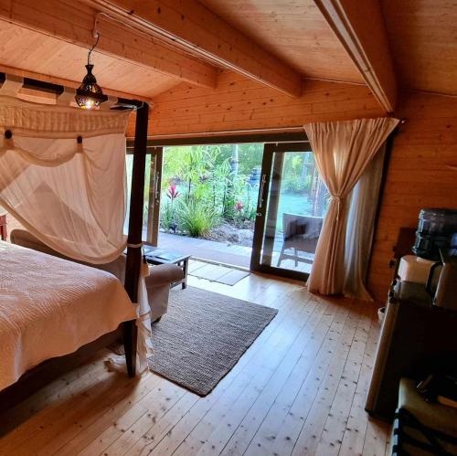 sypialnia z łóżkiem i dużymi przesuwnymi szklanymi drzwiami w obiekcie Healing Garden Retreat - Ubud w mieście Gold Coast