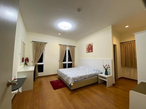 een slaapkamer met een bed en 2 ramen bij Bukit Gambang Waterpark Villa in Kuantan