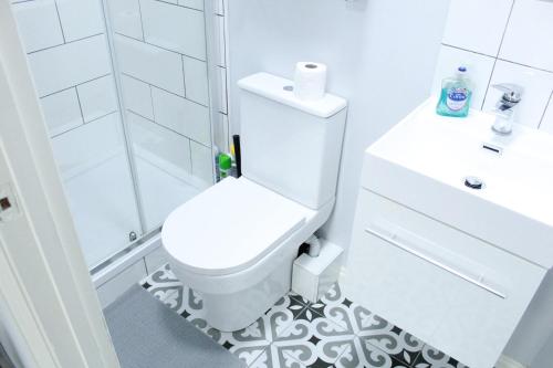 a white bathroom with a toilet and a shower at Private Toilet, 15 min to Central London in London