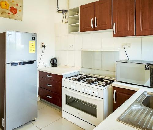 eine Küche mit einem weißen Herd und einem Kühlschrank in der Unterkunft Lovely 2-bedroom house near Aburi in Accra