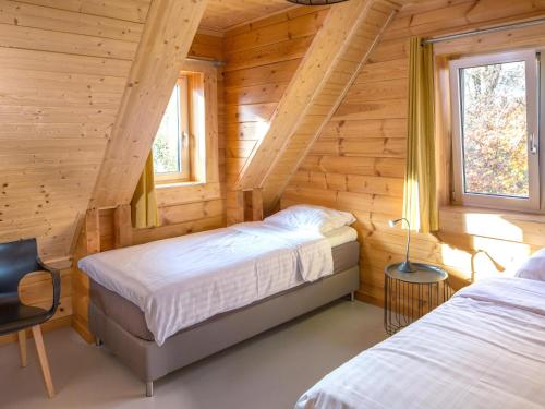 1 Schlafzimmer mit 2 Betten in einem Blockhaus in der Unterkunft Huize Tessel in Slenaken