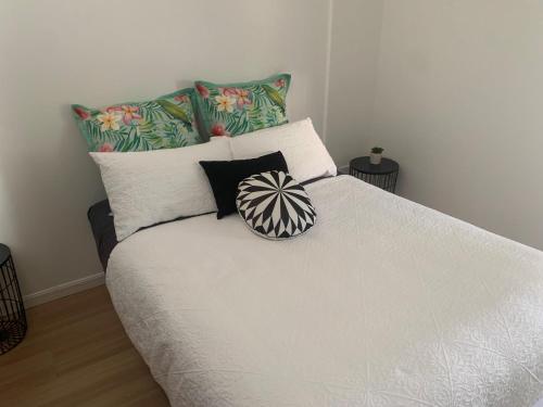 1 dormitorio con cama blanca y almohadas en Yandina Caravan Park en Yandina