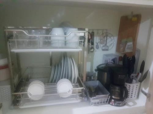 a refrigerator filled with dishes and utensils at SAN REMO OASIS 2BR COMFORT 30sqm in Cebu City