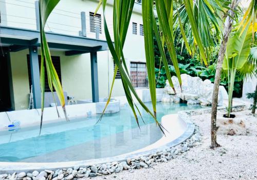 a pool with blue water in front of a house at Hokhmah Heart Hotel in Puerto Morelos