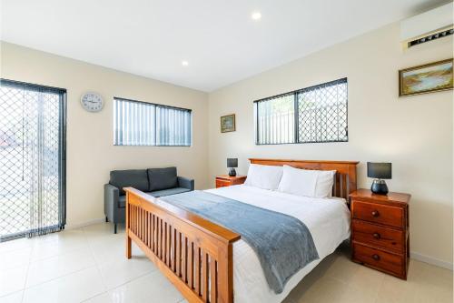 um quarto com uma cama e uma cadeira em 14A Grafton St - Pet friendly air con studio for a couples retreat em Nelson Bay