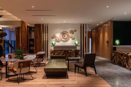 a lobby with chairs and tables and a fireplace at Hotel Indigo Kuala Lumpur on the Park by IHG in Kuala Lumpur