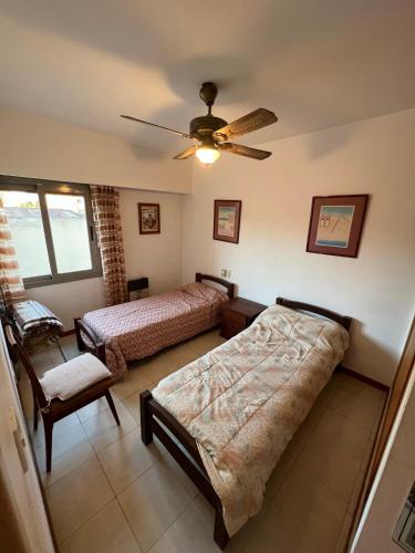 ein Schlafzimmer mit zwei Betten und einem Deckenventilator in der Unterkunft ALQUILO DEPTO AMUEBLADO 2 DORMITORIOS EN MICROCENTRO in Río Cuarto