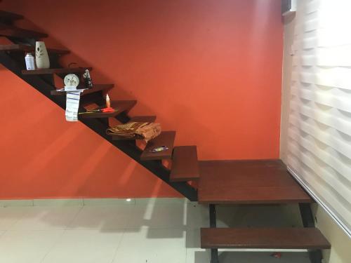 a wooden bench sitting next to a wall with shelves at Kak Ani Homestay in Pasir Gudang