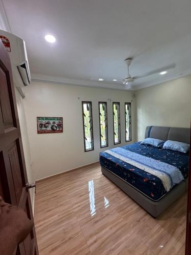Kak Ani Homestay في باسير غونداغ: غرفة نوم وسطها سرير