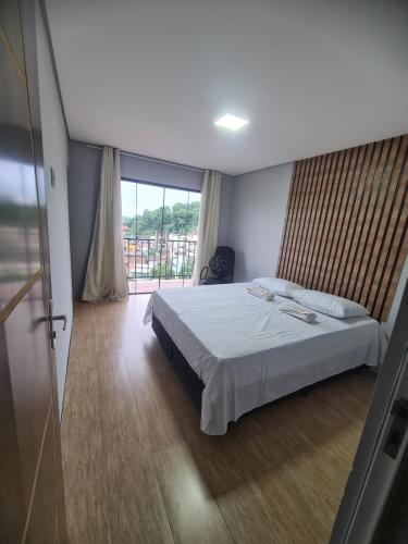 1 dormitorio con cama y ventana grande en Casa Angra vista pro mar en Angra dos Reis