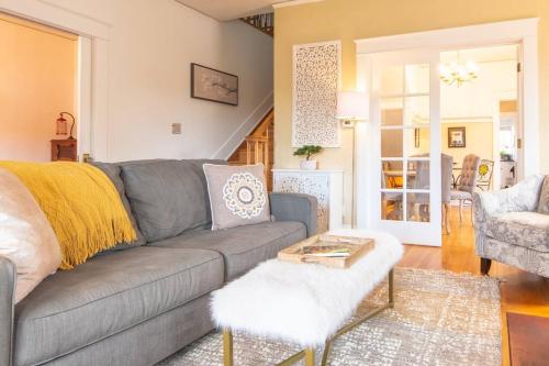 a living room with a gray couch and a table at Manitou Springs White Yarrow Inn House in Manitou Springs