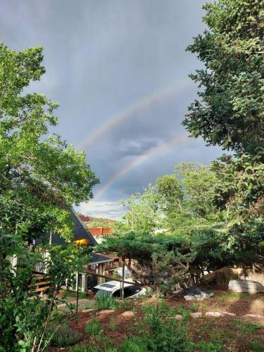 a rainbow in the sky above a house with trees at Manitou Springs White Yarrow Inn House in Manitou Springs