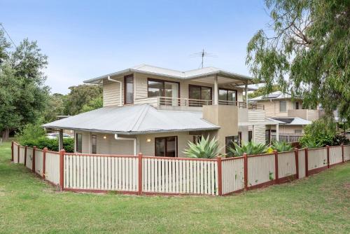 a house with a red fence in front of it at Bayti Retreat in Queenscliff