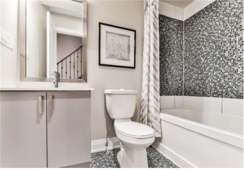 a bathroom with a toilet and a tub and a sink at Immaculate Executive Townhouse 3Br&3Ba at Lawrence Park in Toronto