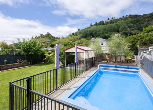 a swimming pool in a yard with a fence at Seymour Sleeps in Nelson